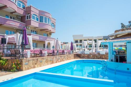 a swimming pool in front of a building at Accommodation Royal Azur in Dobra Voda