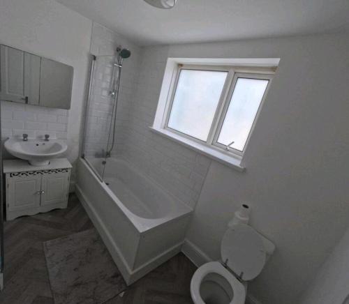 ein weißes Bad mit einem WC und einem Waschbecken in der Unterkunft Double bedroom in Portsmouth