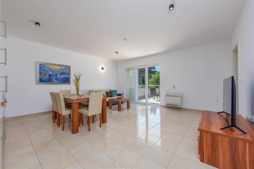 a living room with a dining room table and a tv at Apartments L&D in Biograd na Moru