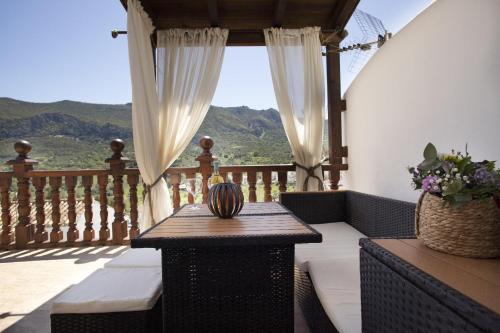 a porch with a table and a view of the mountains at LA POSADA DE LA MUELA in Algodonales