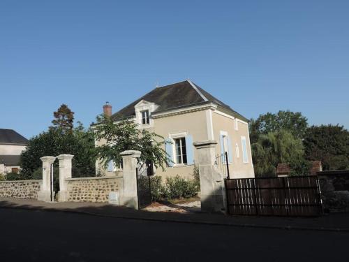 a white house with a fence in front of it at La Gatinelle in Treigny