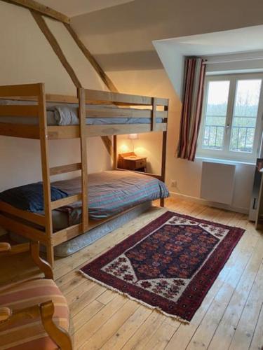 une chambre avec deux lits superposés et un tapis dans l'établissement La Gatinelle, à Treigny