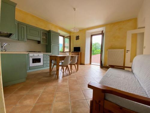 a kitchen with green cabinets and a table and chairs at La Meridiana in Colico