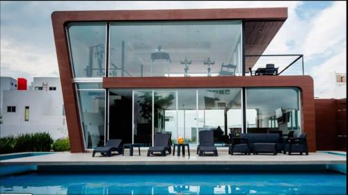 a house with chairs and a swimming pool at MS Excelente Suite Alberca Milenio C32 in Querétaro