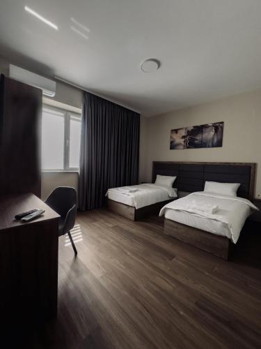 a hotel room with two beds and a desk at Nesvit Hotel in Kyiv