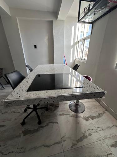 una mesa de mármol en una habitación vacía con ventana en Departamento Amoblado Vista Externa, en Huánuco