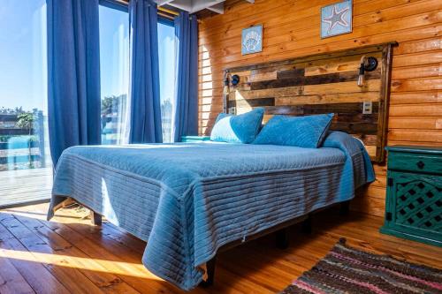 um quarto com uma cama e uma parede de madeira em PEZ HOUSE em Pichilemu