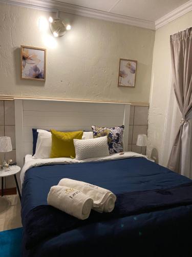 a bedroom with a large bed with towels on it at Lerato's in Vanderbijlpark