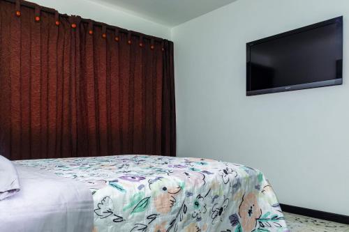 a bedroom with a bed and a flat screen tv at Hospedaje juandi in Medellín