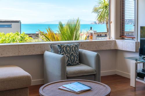 a living room with a view of the ocean at The Sands - Apartment 19 - Stay Waiheke in Onetangi