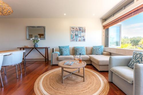 a living room with a couch and a table at The Sands - Apartment 19 - Stay Waiheke in Onetangi
