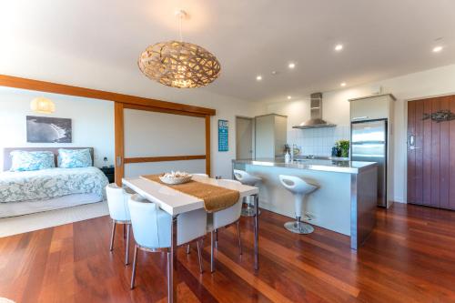 a kitchen and living room with a bed and a table at The Sands - Apartment 19 - Stay Waiheke in Onetangi