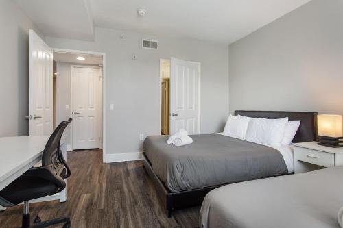 a small hotel room with two beds and a desk at Cute Santa Monica Apartment with Pool in Los Angeles