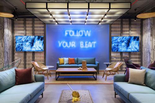 a lobby with couches and a blue wall with follow your heart at Aloft Playa del Carmen in Playa del Carmen
