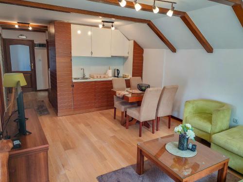 a living room with a table and a kitchen at or'o apartments in Žabljak