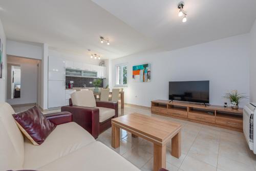 uma sala de estar com um sofá e uma televisão em Apartments L&D em Biograd na Moru