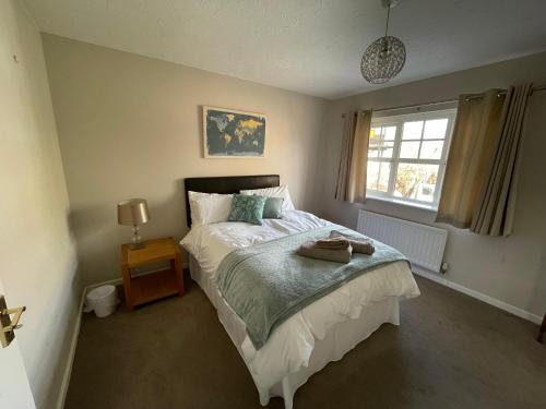 Schlafzimmer mit einem Bett und einem Fenster in der Unterkunft Quiet 3 bed home in Stafford