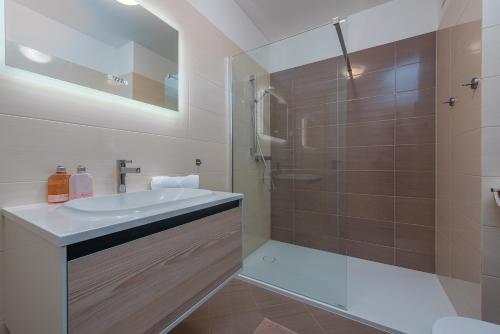a bathroom with a white sink and a shower at Apartments L&D in Biograd na Moru