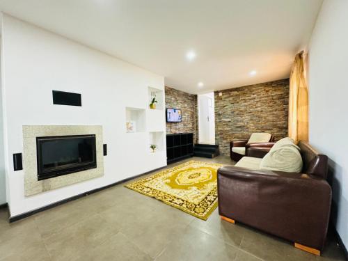 a living room with a couch and a television at Casa Avô Cantoneiro - Cepães Marinhas in Cepães