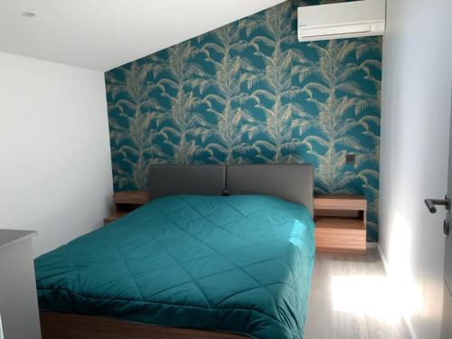 a bedroom with a green bed and a blue wall at Villa STEVAN in Bonifacio
