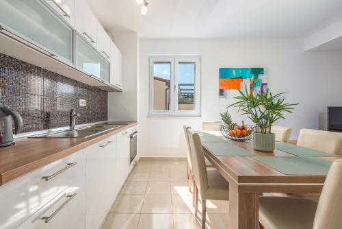 a kitchen and dining room with a table and chairs at Apartments L&D in Biograd na Moru