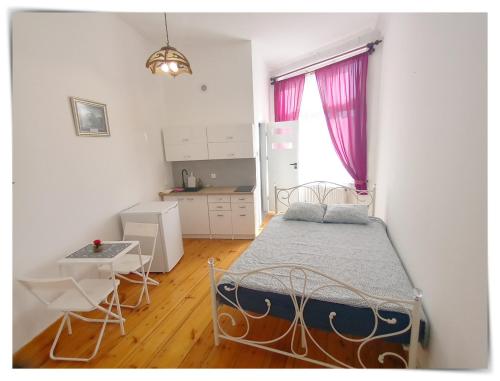 1 dormitorio con cama, mesa y cocina en SouvenirAppart Sniadeckich 45, en Bydgoszcz