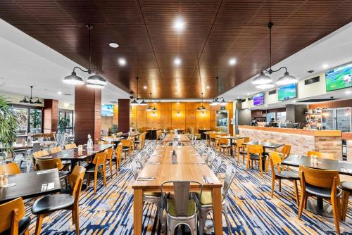 a dining room with wooden tables and chairs at Morayfield Tavern in Morayfield