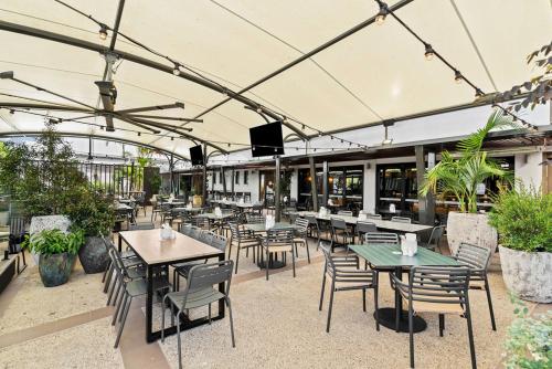 an outdoor patio with tables and chairs and a television at Morayfield Tavern in Morayfield