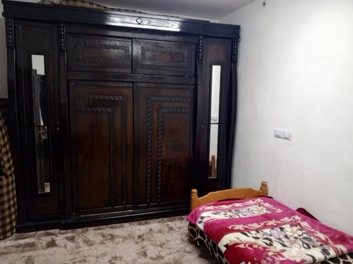 - une chambre avec une grande armoire en bois et un lit dans l'établissement Jordan- almafraq, à Al Mafraq