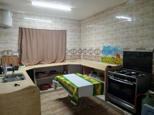 - une cuisine avec une table, une cuisinière et un évier dans l'établissement Jordan- almafraq, à Al Mafraq