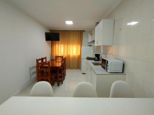 a kitchen and dining room with a table and a microwave at Marsán in Arzúa