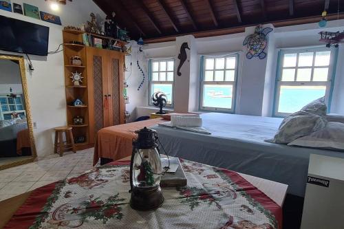 a bedroom with a large bed and a table at Casa no Paraíso - Pântano do Sul - Florianópolis in Florianópolis