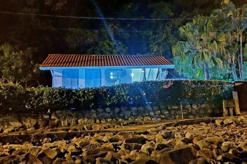 a blue building with a large pile of rocks at Casa no Paraíso - Pântano do Sul - Florianópolis in Florianópolis