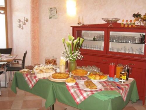 a table with food on a green table cloth at Agriturismo B&B Il Girasole in Oriago Di Mira