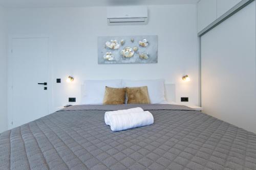 een slaapkamer met een bed met een witte handdoek erop bij Apartmani Kika in Brela