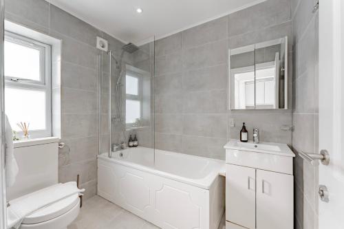 La salle de bains est pourvue d'une baignoire, de toilettes et d'un lavabo. dans l'établissement Cosy & Stylish Apmt w/ Fast Wifi, à Londres