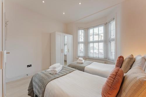 - une chambre avec 2 lits et une fenêtre dans l'établissement Cosy & Stylish Apmt w/ Fast Wifi, à Londres