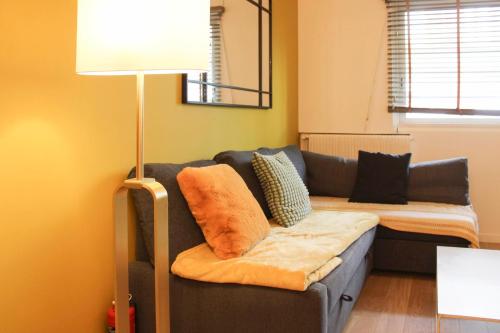 un salon avec un canapé et une lampe dans l'établissement Cosy apartment at the gates of Paris, à Montreuil