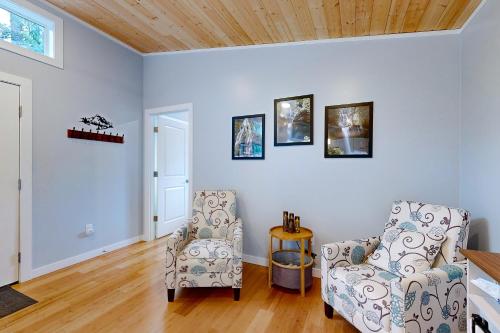 a living room with two chairs and a wooden ceiling at River Time Retreat in Carson
