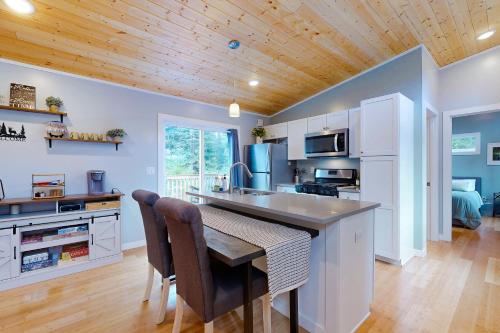 a kitchen with white cabinets and a wooden ceiling at River Time Retreat in Carson