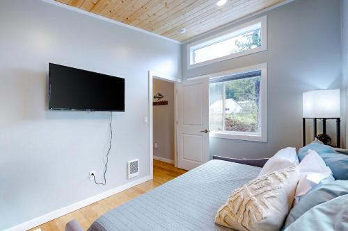 a bedroom with a bed and a flat screen tv on a wall at River Time Retreat in Carson