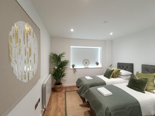 a bedroom with two beds and a window at Snuggle Inn - Riverside Apartments - Views Over looking London River Thames, Close to O2 Arena, London Excel, London City Airport, Thames Clipper- River Boat Service, Woolwich Ferry, Onsite parking, TWIN ROOM OPTION available in London