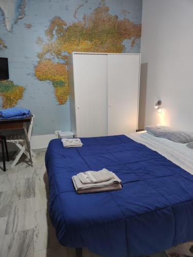 ein Schlafzimmer mit einem blauen Bett mit einer Karte an der Wand in der Unterkunft Monolocale Seaside in Reggio di Calabria
