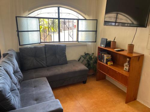uma sala de estar com um sofá e uma televisão em Casita tranquila em Sayulita