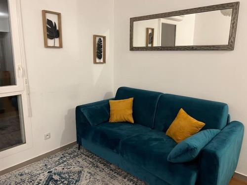 un canapé bleu dans un salon avec un miroir dans l'établissement Studio proche Part-Dieu, à Villeurbanne