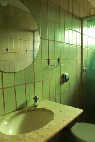 a bathroom with a sink and a mirror and a toilet at Albergue Cultural São Salomão in Recife