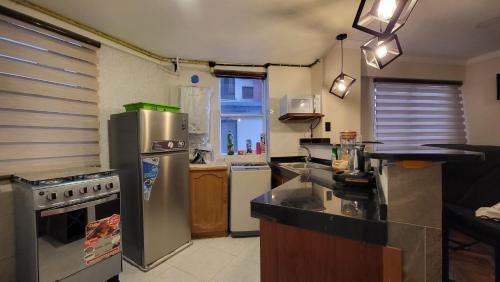 a kitchen with a stainless steel refrigerator and a sink at Céntrico y cómodo in La Paz