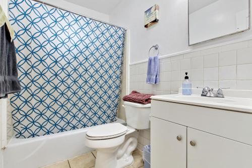 a bathroom with a toilet and a sink and a shower at Pao and Pui in Kenner