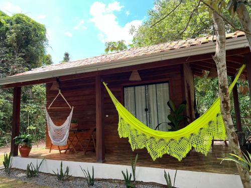 una cabaña de madera con una hamaca frente a ella en Pousada e Restaurante Sumaúma en Santarém