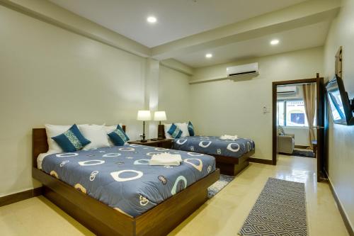 a bedroom with two beds and a mirror at Louis' Apartments in Placencia Village